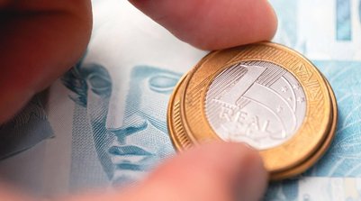 Moedas de um real sobre notas de 100 (Imagem gerada com auxílio IA/Leonardo Albertino) (Foto: Divulgação / InfoMoney)