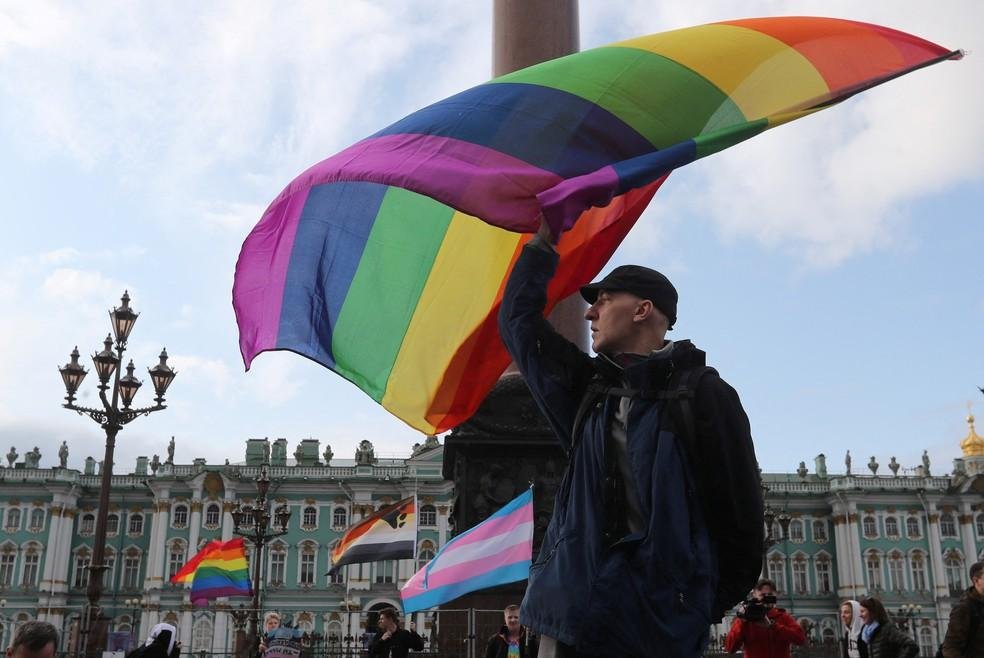 Um participante agita uma bandeira do arco-íris durante o comício da comunidade LGBT no centro de São Petersburgo, na Rússia, em 3 de agosto de 2019