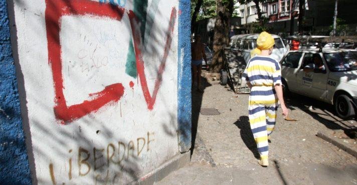 Popular passa diante de muro pichado com as iniciais do Comando Vermelho